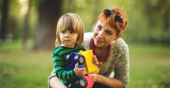 Babysitterin spielt mit einem Kind in der Natur
